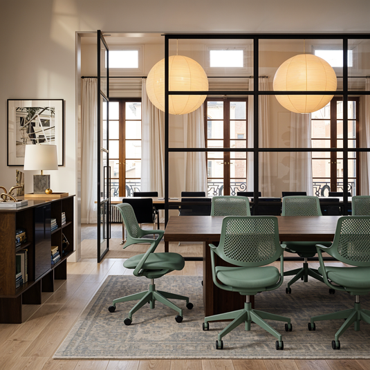 Modern office space with green chairs and a large window.