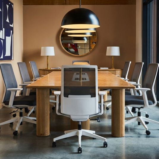 Modern conference room with wooden table and chairs, large window, and abstract art on the wall.