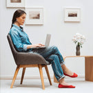 Woman using a laptop in a modern living room.
