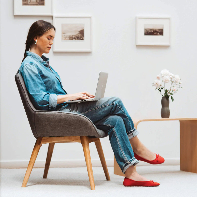 Load image into Gallery viewer, Woman using a laptop in a modern living room.
