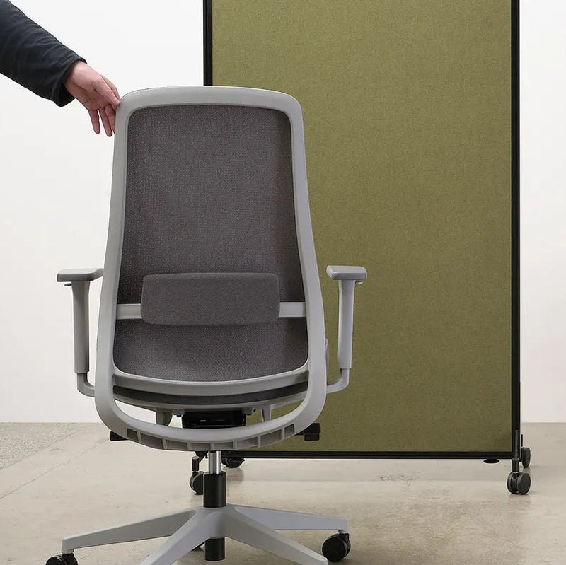 Load image into Gallery viewer, Gray office chair being adjusted by a person with a white wall and green partition in the background.
