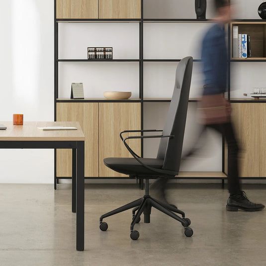Modern office setup with a desk, chair, and bookshelf in a minimalistic office.