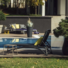 charcoal sunlounger with yellow cushion and outdoor pool