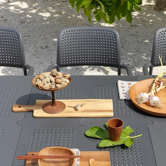 outdoor charcoal chair and table with food and wooden plates