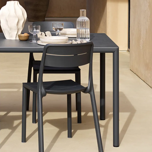 Modern black dining table with chairs in a minimalistic setting