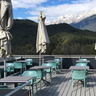 mint outdoor chairs and taupe tables with mountains and umbrellas