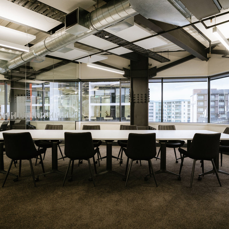 Load image into Gallery viewer, Modern conference room with long table and chairs in a cityscape setting
