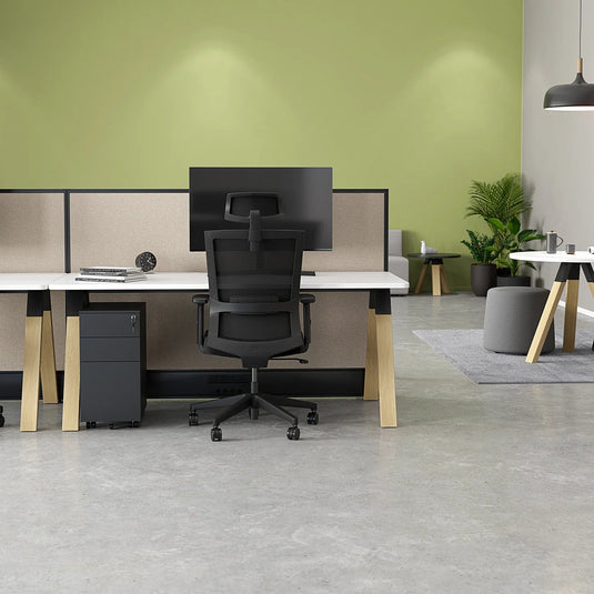 Modern office space with desks, chairs, and green walls