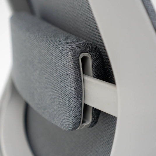 Close-up of a car seat belt buckle and strap on a gray car interior.