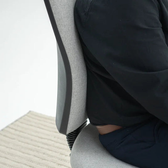 Person sitting on a gray office chair with a blurred background